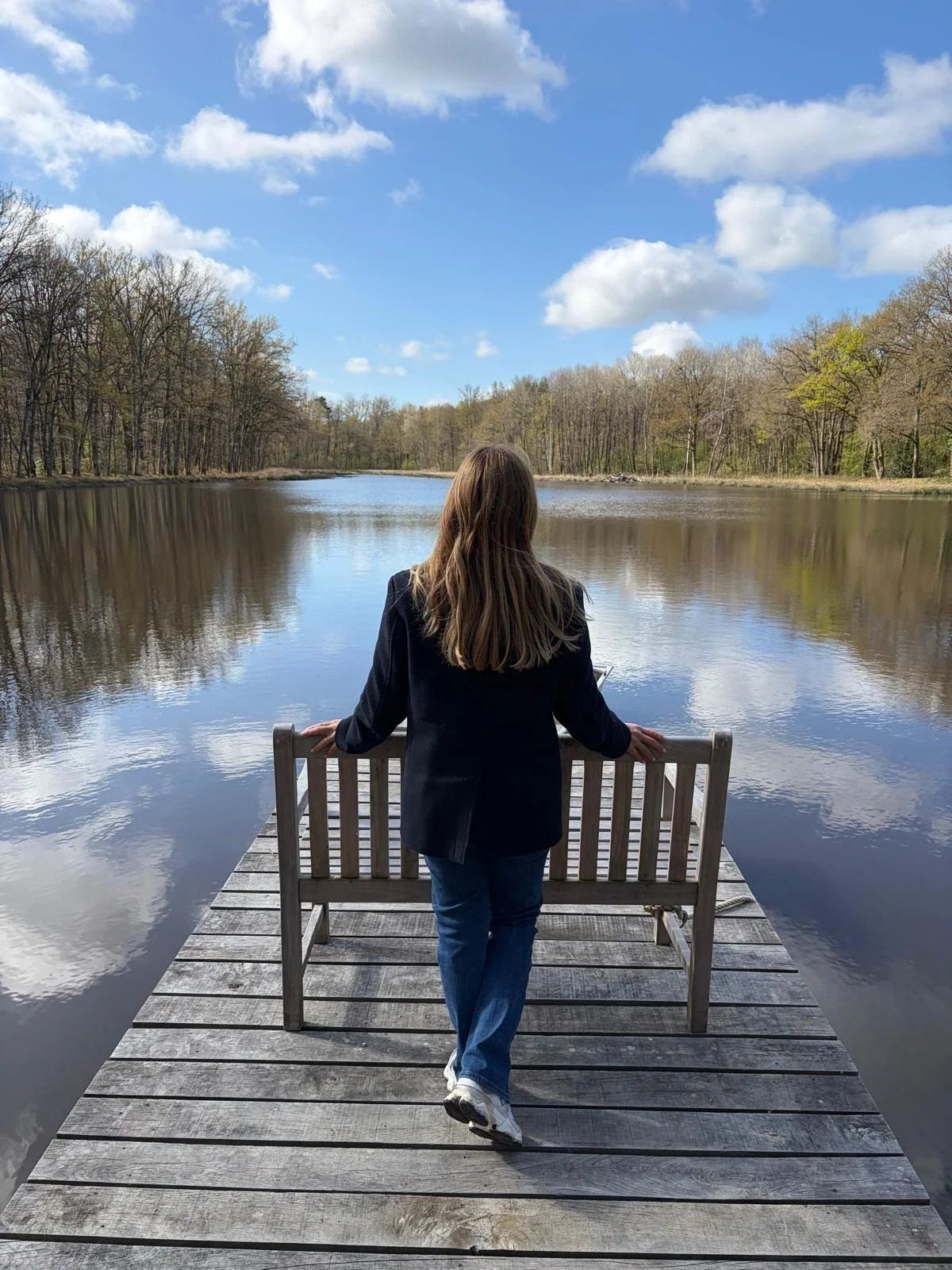 Marta on a wooden jetty, looking out over a still lake